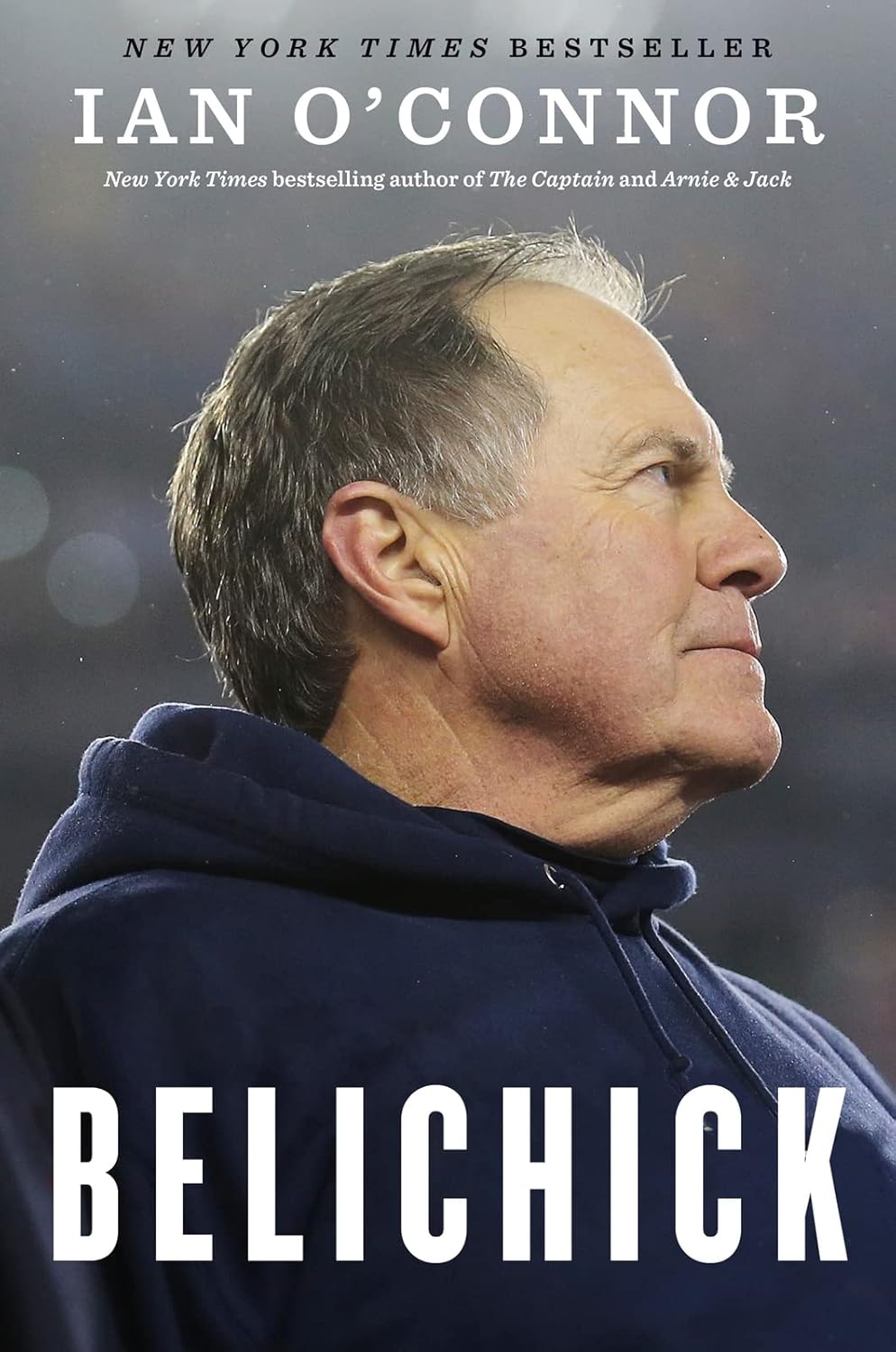 Book cover of 'Belichick' by Ian O'Connor featuring a man in a blue jacket against a blurred background.